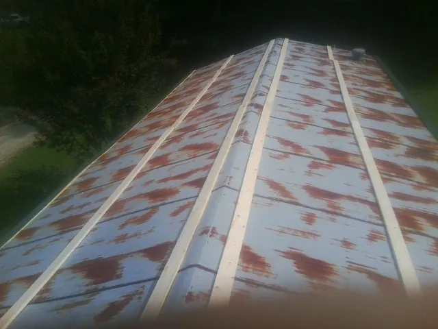 Rusted metal roof panels with new wood purlins before replacement — Storm Damage Roof Repair in Petal by Roofing Brothers