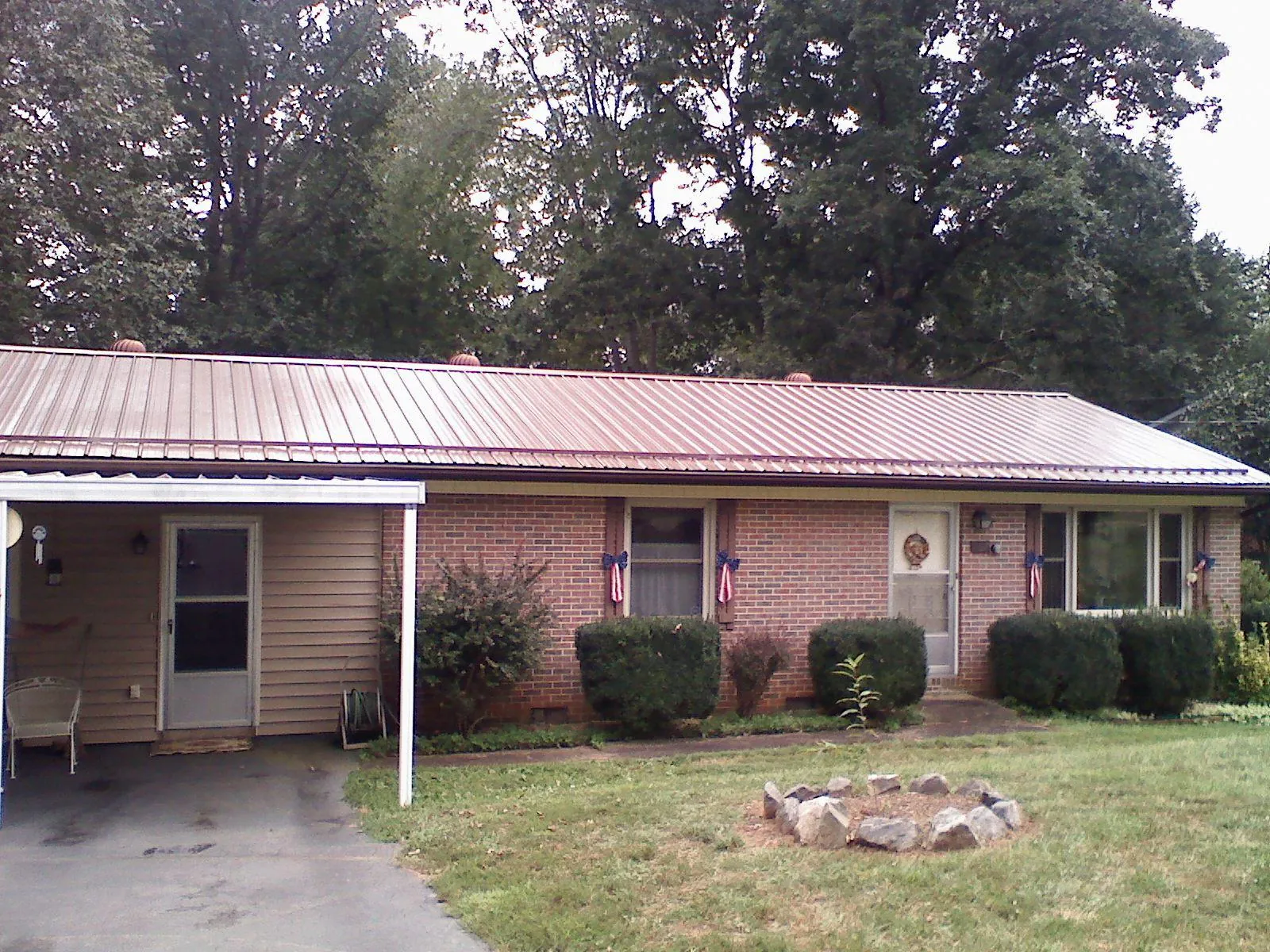 Bronze metal roof and carport on a brick ranch home — Roof Repair work by our crew in Petal